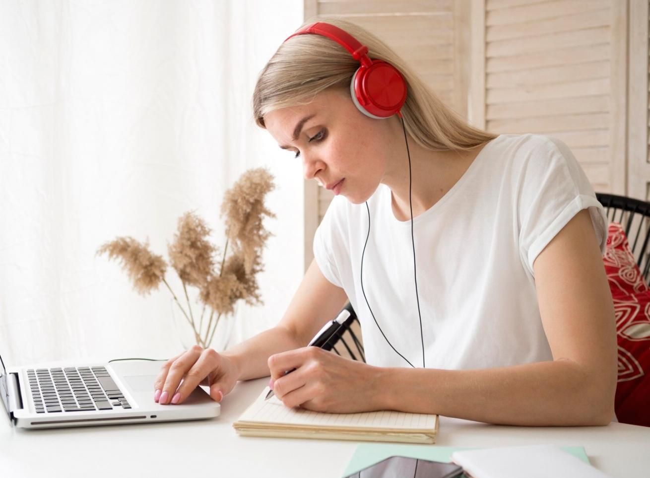 Poste de travail configuré pour suivre une formation en ligne sur l'investissement avec plusieurs écrans affichant des graphiques financiers